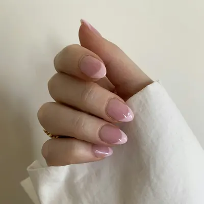 Short, rounded nails painted a sheer pink